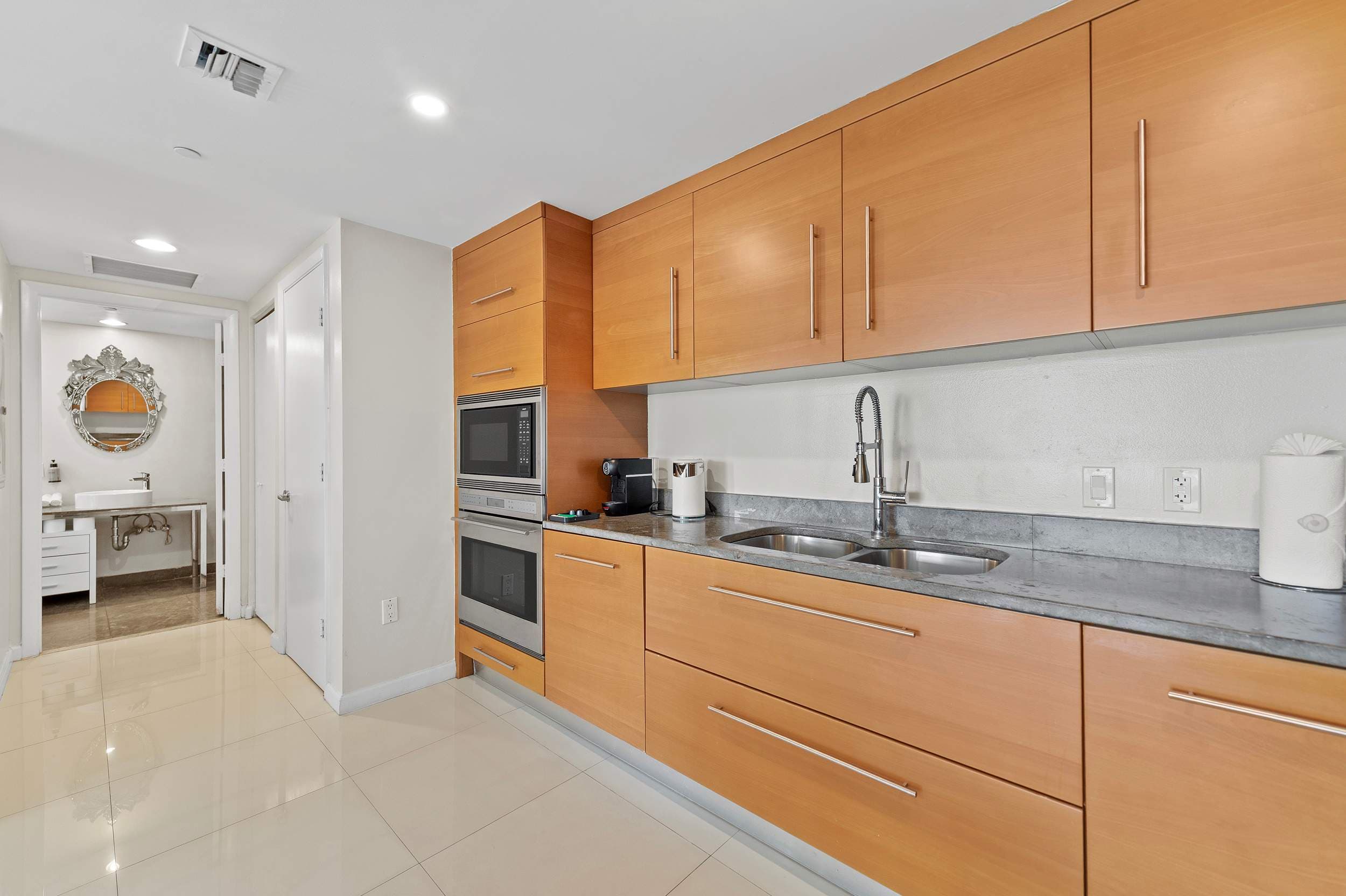 Wood kitchen cabinets beside the bathroom entrance.