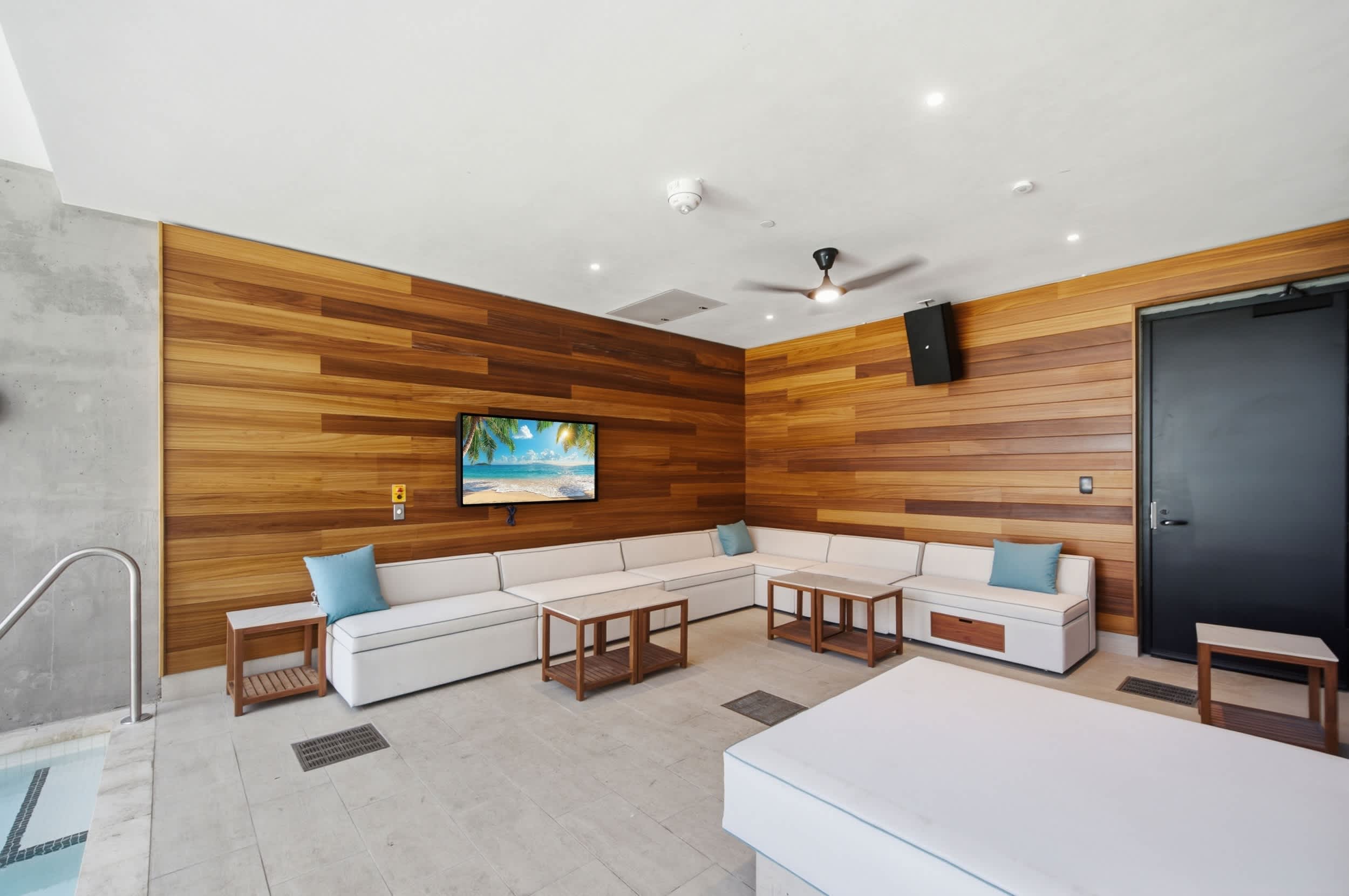 Covered terrace with pale sofas and wood walls.