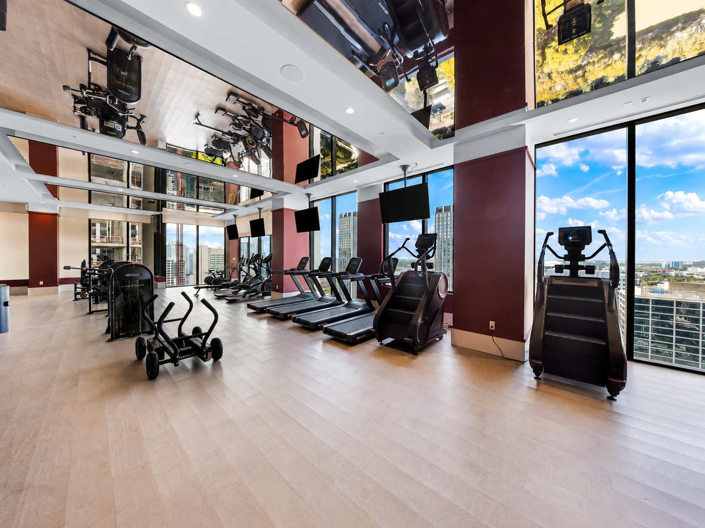 Gym with exercise machines and large windows.