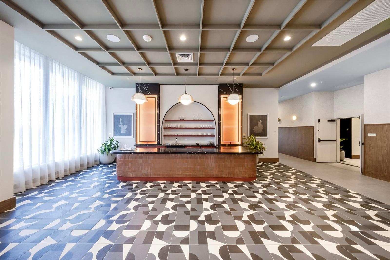 Lobby with a reception desk and patterned floor.