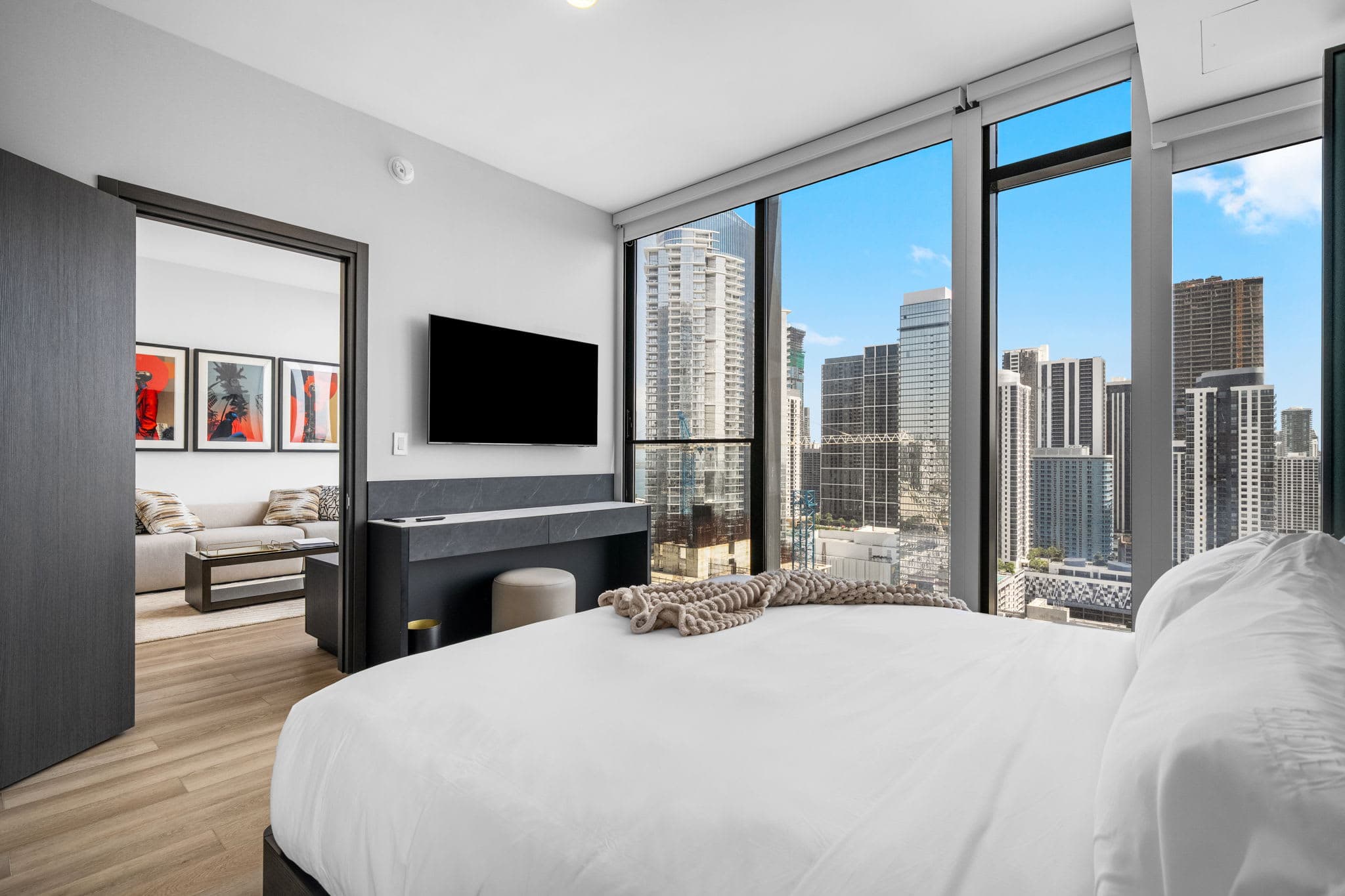 Bed facing a wall-mounted television.